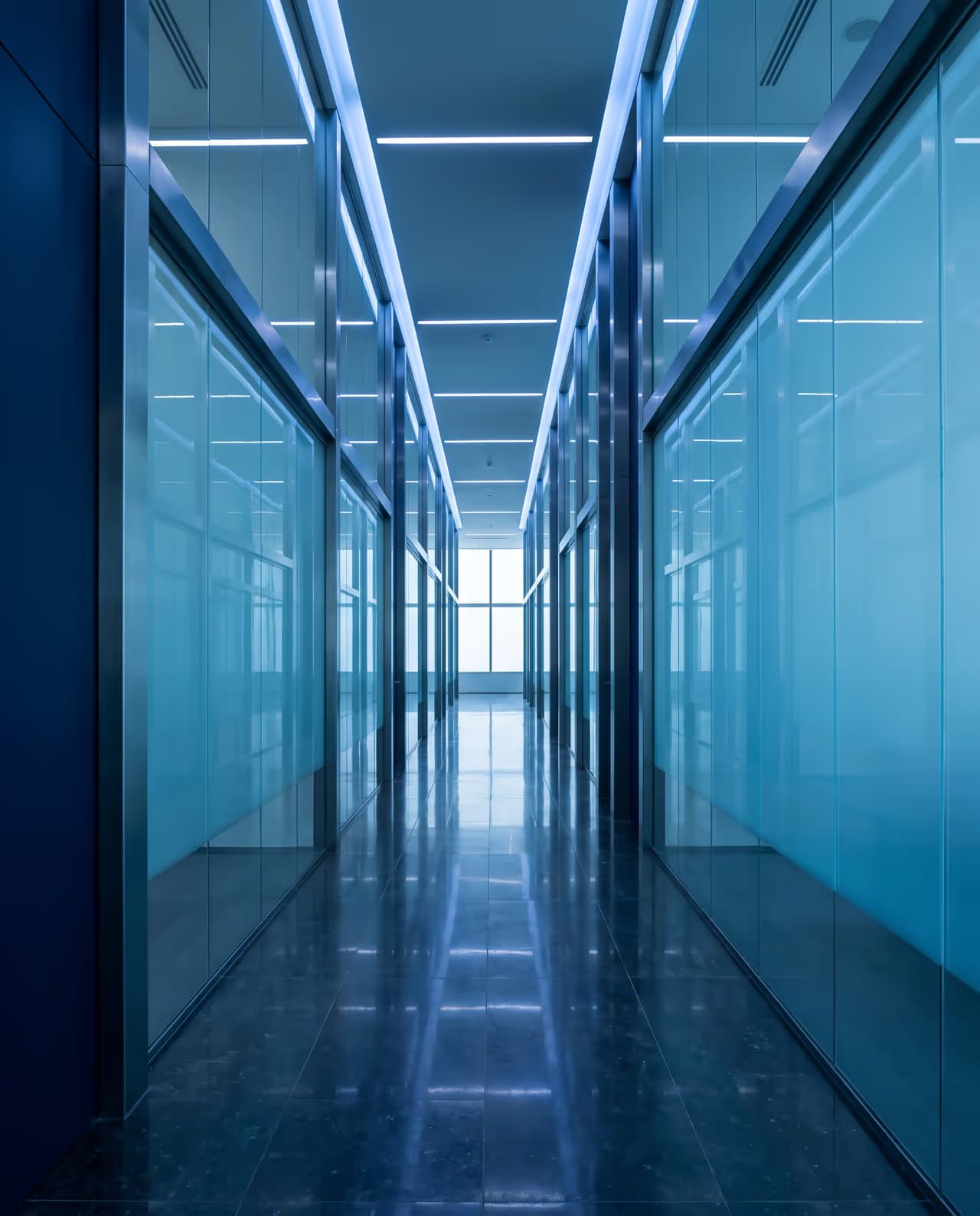 Corridoio direzionale con vetrate e prospettiva verticale in luce fredda